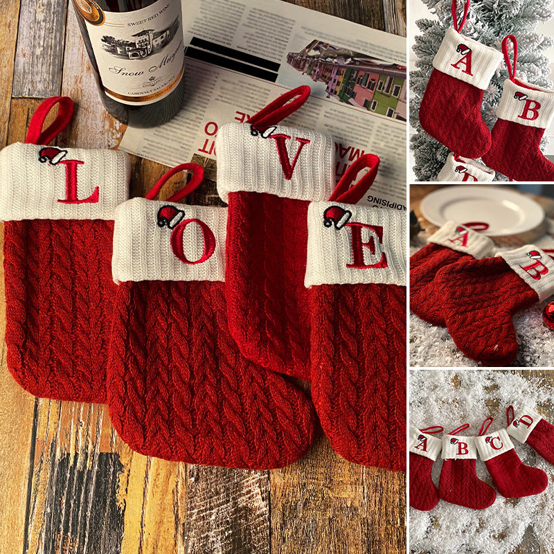 "Barn julstrumpor, röd med broderad bokstav och färgglatt godismönster, perfekt för juldekoration och barnens glädje."