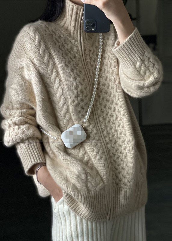 Beige damkappa med dragkedja och stickad design, elegant och mysig för både vardag och officiella tillfällen.