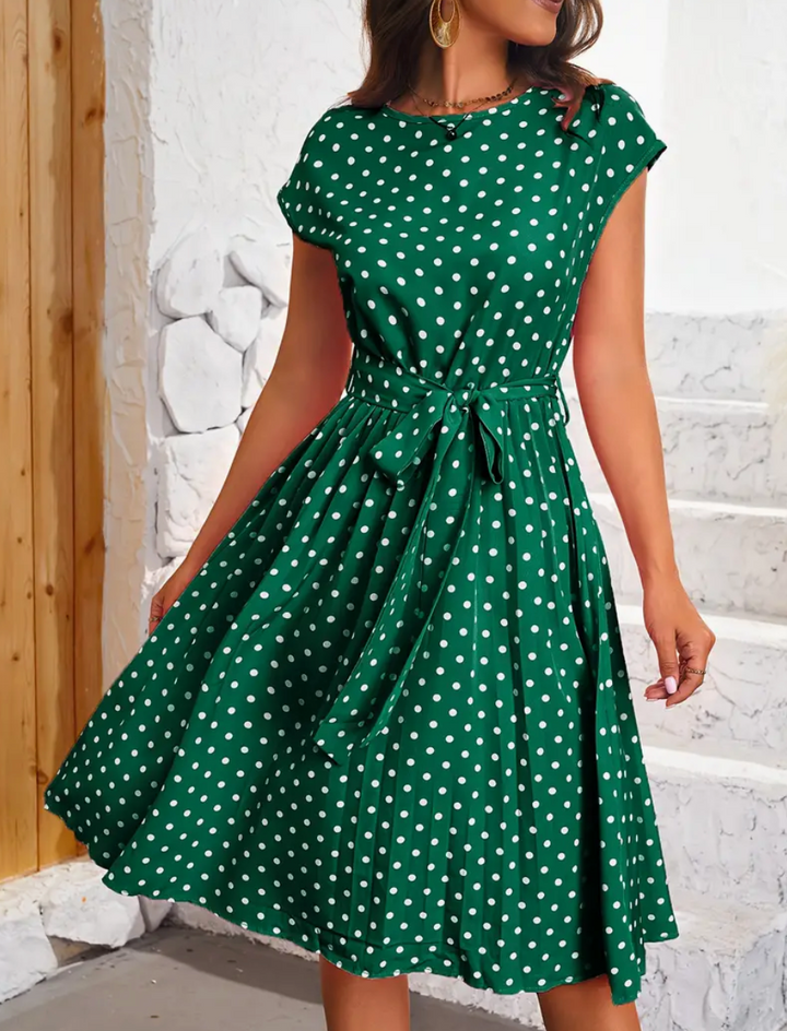 "Dam Retro Chic Polka Dot Swingklänning i lekfullt mönster med flödande material, perfekt för vår- och sommarstil."