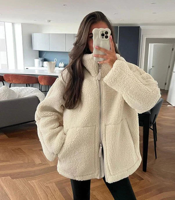"Dam lång teddyjacka i beige och vit med lös passform, mjuk textur, perfekt för värme och stil under kalla dagar."