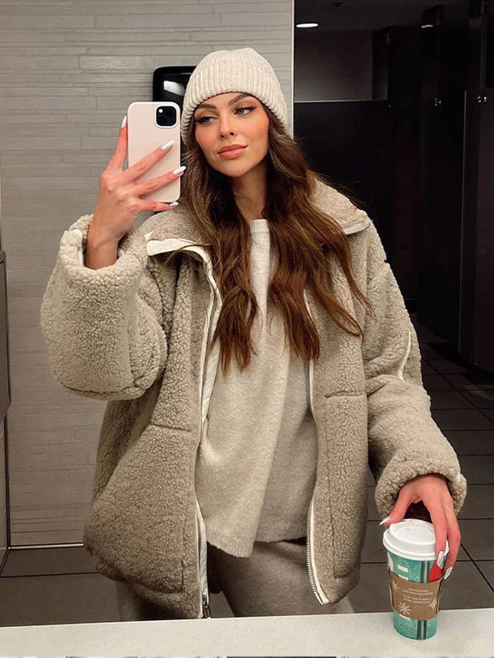 "Dam lång teddyjacka i beige och vit med lös passform, mjuk textur, perfekt för värme och stil under kalla dagar."