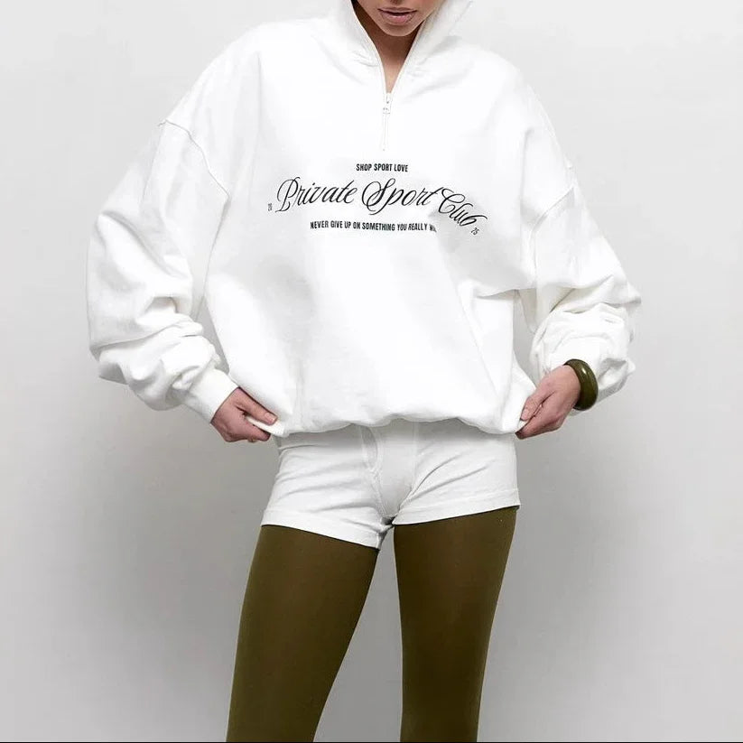 "Dam oversized tröja med halv dragkedja och djärvt bokstavstryck, idealisk för stil och komfort."