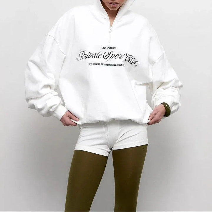 "Dam oversized tröja med halv dragkedja och djärvt bokstavstryck, idealisk för stil och komfort."