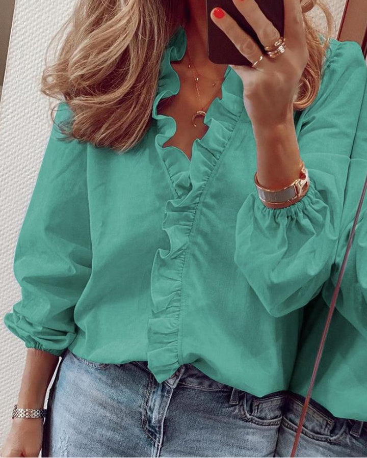 "Damblus i polyester med chic ruffle-design och smickrande V-ringning, feminin look för både vardag och fest."