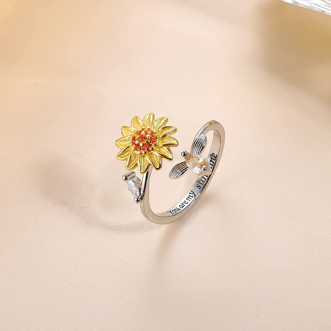 "Damer Solros Fidget Ring: Elegant ångestlindrande ring med roterbar blommig design i guld och cubic zirconia."