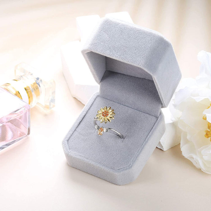 "Damer Solros Fidget Ring: Elegant ångestlindrande ring med roterbar blommig design i guld och cubic zirconia."