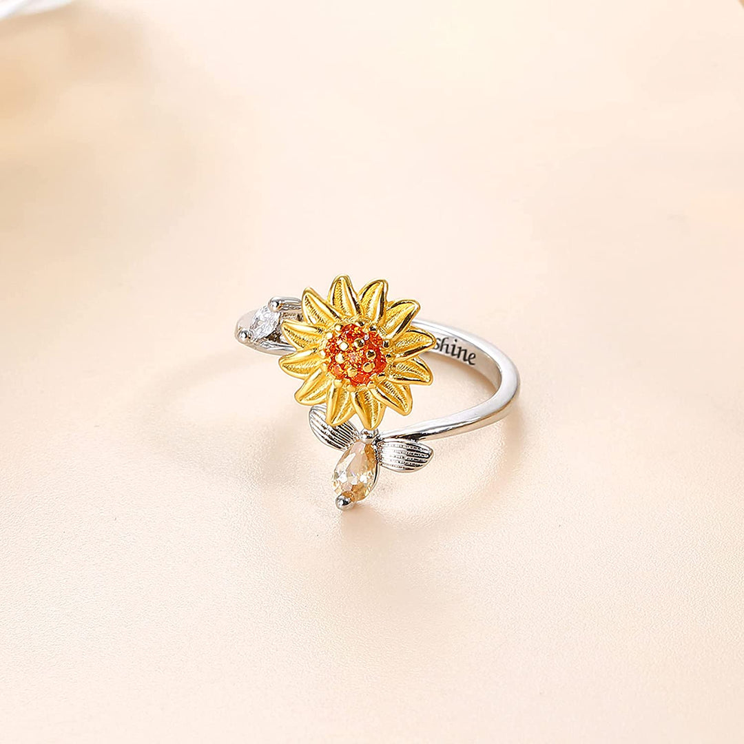 "Damer Solros Fidget Ring: Elegant ångestlindrande ring med roterbar blommig design i guld och cubic zirconia."