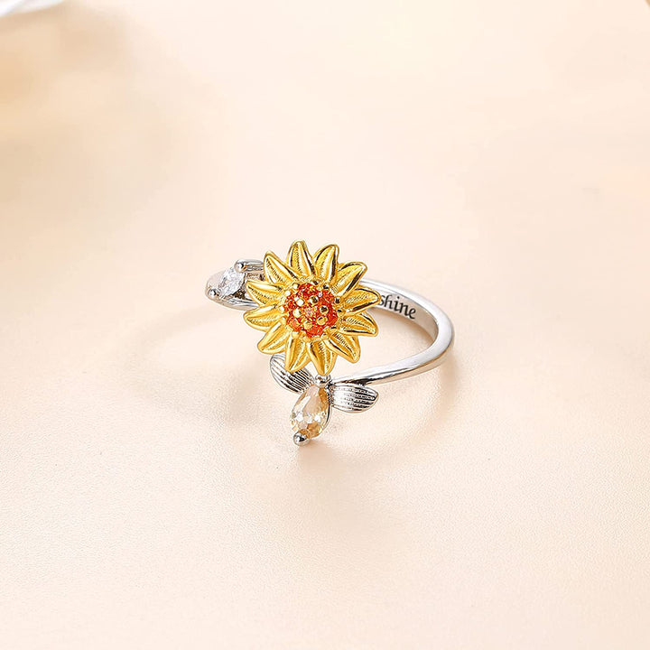 "Damer Solros Fidget Ring: Elegant ångestlindrande ring med roterbar blommig design i guld och cubic zirconia."