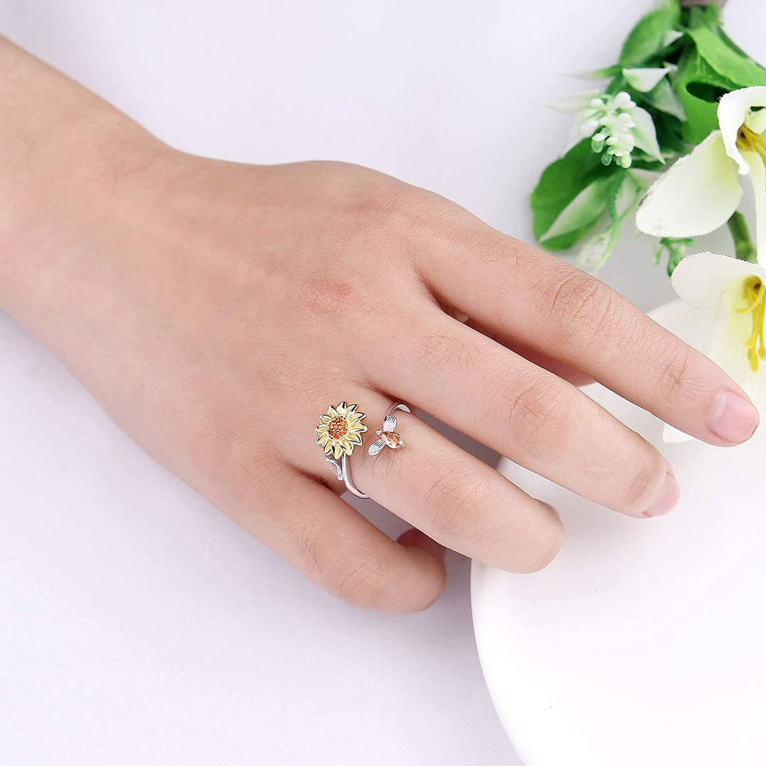 "Damer Solros Fidget Ring: Elegant ångestlindrande ring med roterbar blommig design i guld och cubic zirconia."