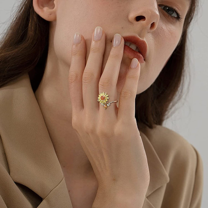 "Damer Solros Fidget Ring: Elegant ångestlindrande ring med roterbar blommig design i guld och cubic zirconia."