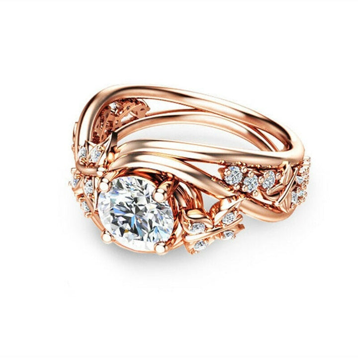 "Damer fingerring med rhinestones, fjäril och blomma i roséguld, sett framifrån."