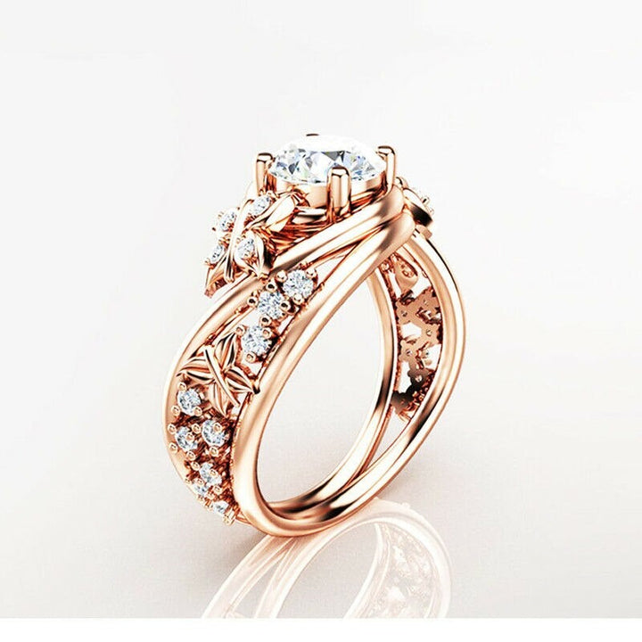 "Damer fingerring med rhinestones, fjäril och blomma i roséguld, sett framifrån."