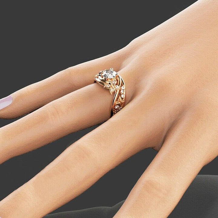 "Damer fingerring med rhinestones, fjäril och blomma i roséguld, sett framifrån."