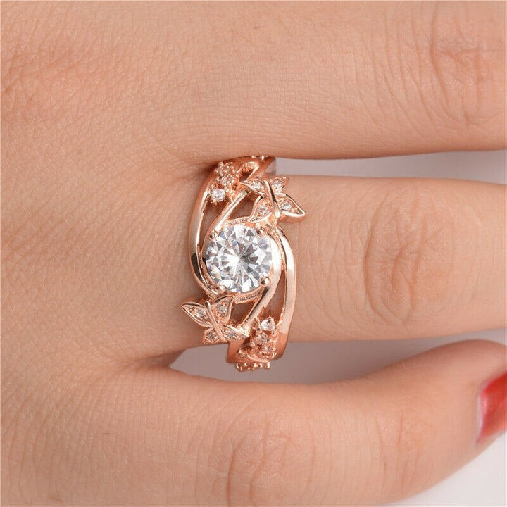 "Damer fingerring med rhinestones, fjäril och blomma i roséguld, sett framifrån."