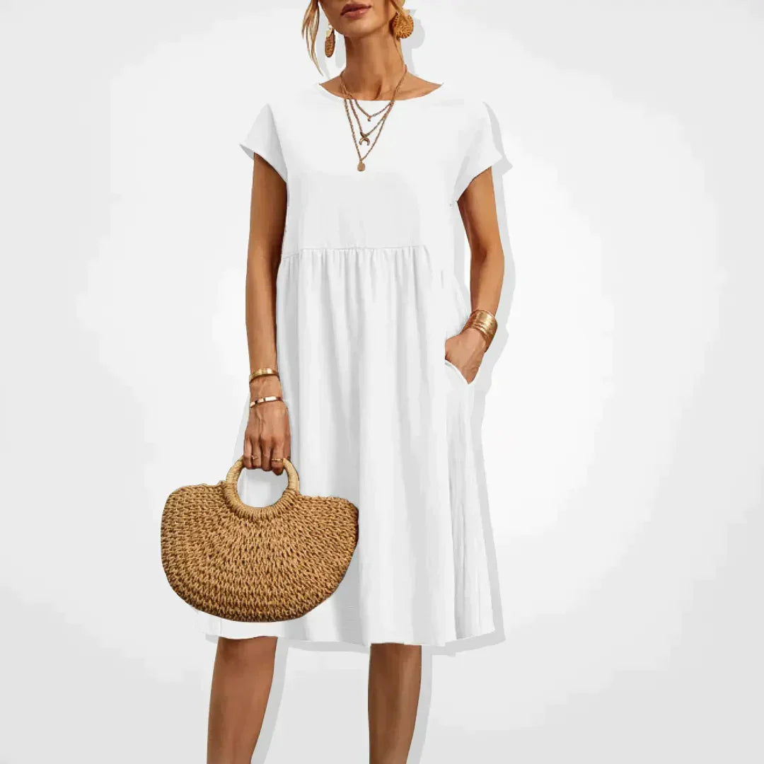"Damernas Empire sommarklänning i lätt material med smickrande silhuett, elegant för både stranddagar och kvällsfester."