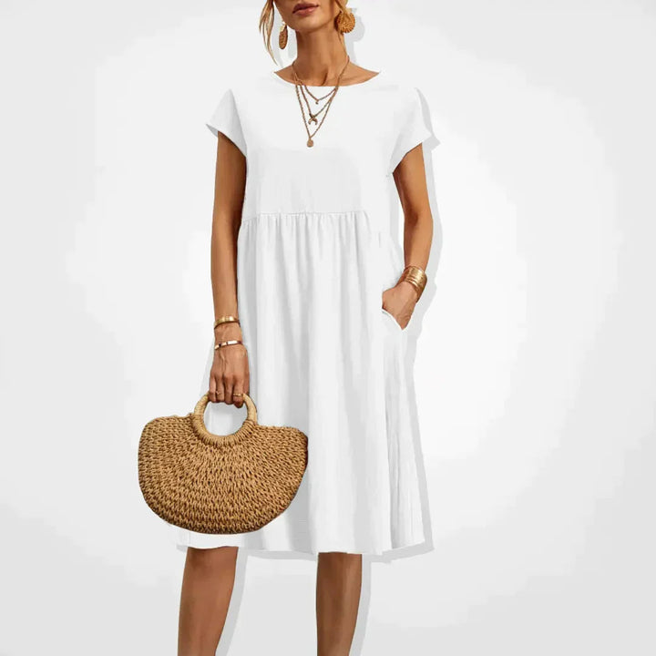"Damernas Empire sommarklänning i lätt material med smickrande silhuett, elegant för både stranddagar och kvällsfester."