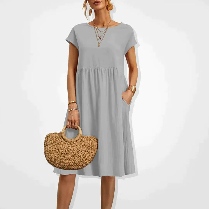 "Damernas Empire sommarklänning i lätt material med smickrande silhuett, elegant för både stranddagar och kvällsfester."