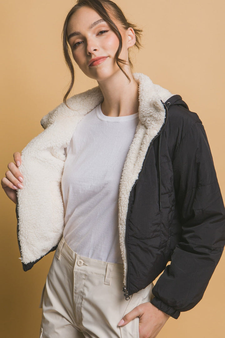 "Damernas vändbara cropped jacka med huva, sherpa på ena sidan, nylon på andra, sett framifrån för urban stil."