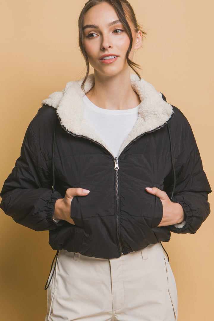 "Damernas vändbara cropped jacka med huva, sherpa på ena sidan, nylon på andra, sett framifrån för urban stil."