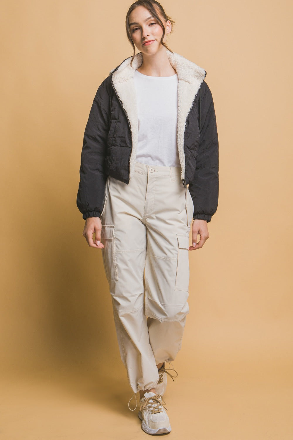 "Damernas vändbara cropped jacka med huva, sherpa på ena sidan, nylon på andra, sett framifrån för urban stil."