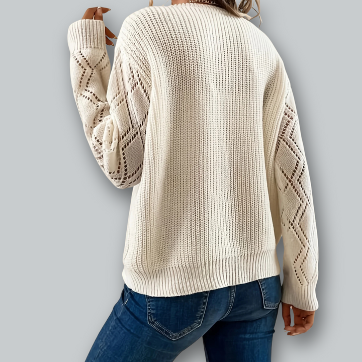 "Damstickad V-ringad pullover med mjuk textur och detaljerade ärmar, perfekt för elegant lager-på-lager stil."