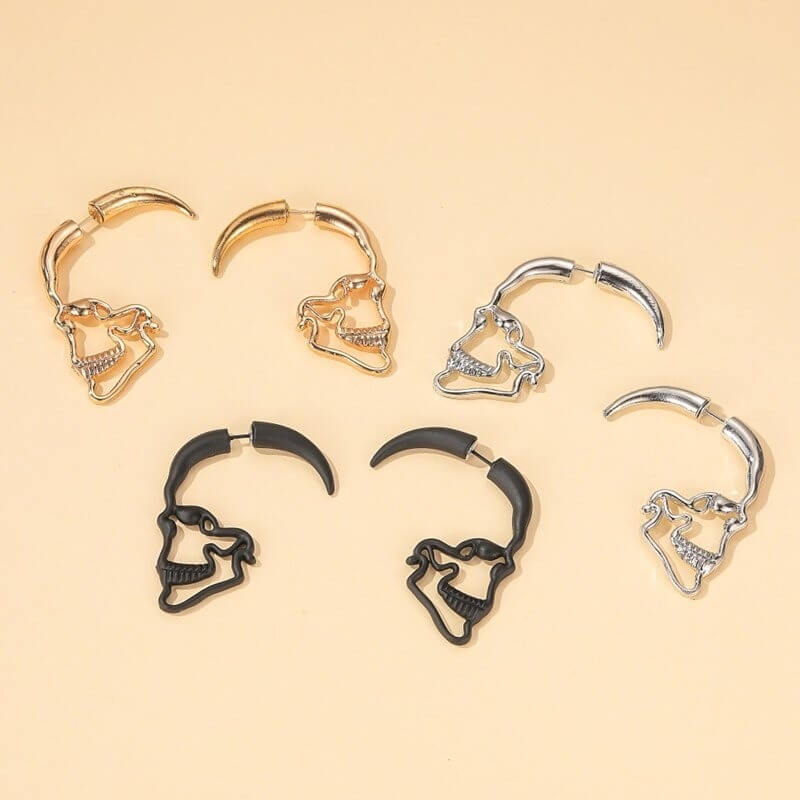 "Djärva dödskalleörhängen i punkstil för kvinnor, tillgängliga i guld, silver eller svart, med detaljerad skulpturdesign."