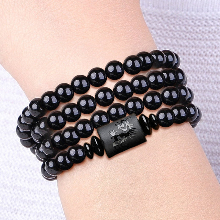 "Drake & Fenix Yin-Yang armband i svart och grått, designat för män och kvinnor med glaspärlor för harmoni och balans."
