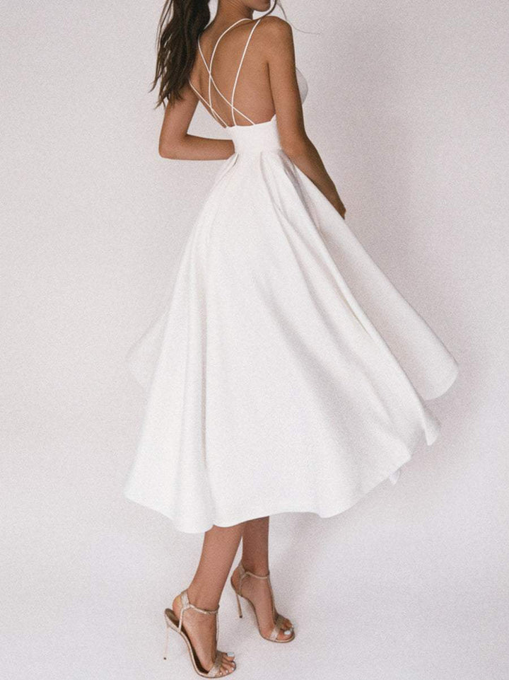 "Elegant Boho Chic V-ringad klänning i vitt med smickrande detaljer, idealisk för sommarens äventyr för kvinnor."