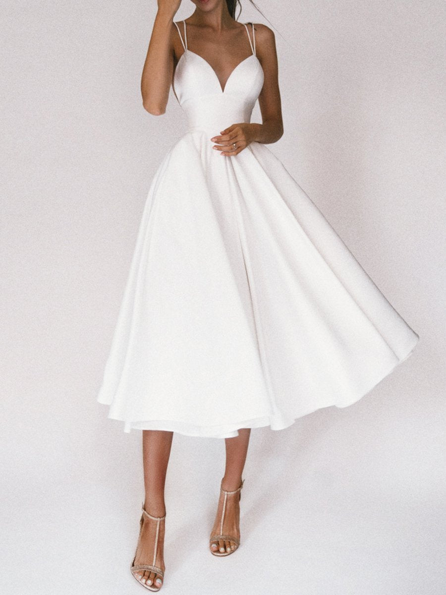 "Elegant Boho Chic V-ringad klänning i vitt med smickrande detaljer, idealisk för sommarens äventyr för kvinnor."