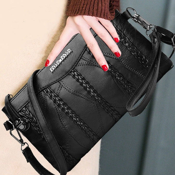 "Elegant crossbody clutch väska i svart PU-läder för kvinnor, med modern design och plats för nödvändigheter."