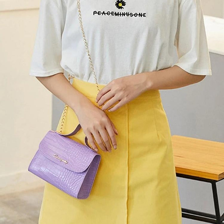 "Elegant crossbody-väska för kvinnor med kedjedetalj i svart, kedjerem och flikdesign, damaccessoar."