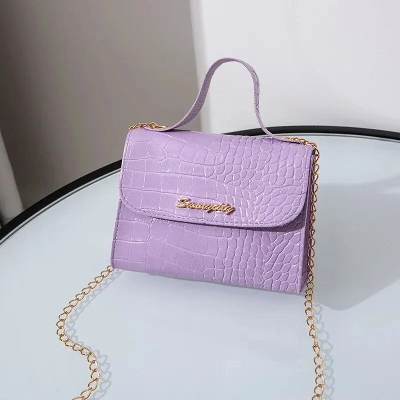 "Elegant crossbody-väska för kvinnor med kedjedetalj i svart, kedjerem och flikdesign, damaccessoar."