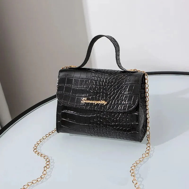 "Elegant crossbody-väska för kvinnor med kedjedetalj i svart, kedjerem och flikdesign, damaccessoar."