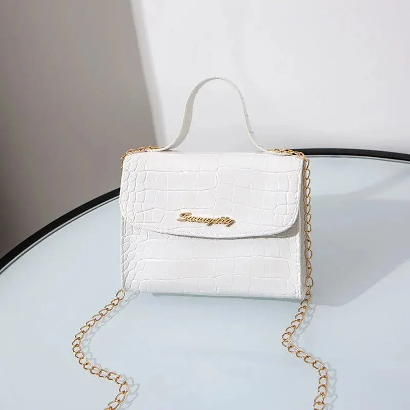 "Elegant crossbody-väska för kvinnor med kedjedetalj i svart, kedjerem och flikdesign, damaccessoar."
