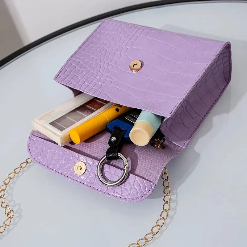 "Elegant crossbody-väska för kvinnor med kedjedetalj i svart, kedjerem och flikdesign, damaccessoar."