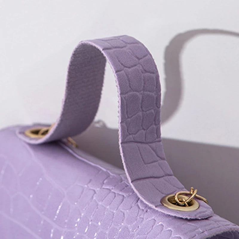 "Elegant crossbody-väska för kvinnor med kedjedetalj i svart, kedjerem och flikdesign, damaccessoar."