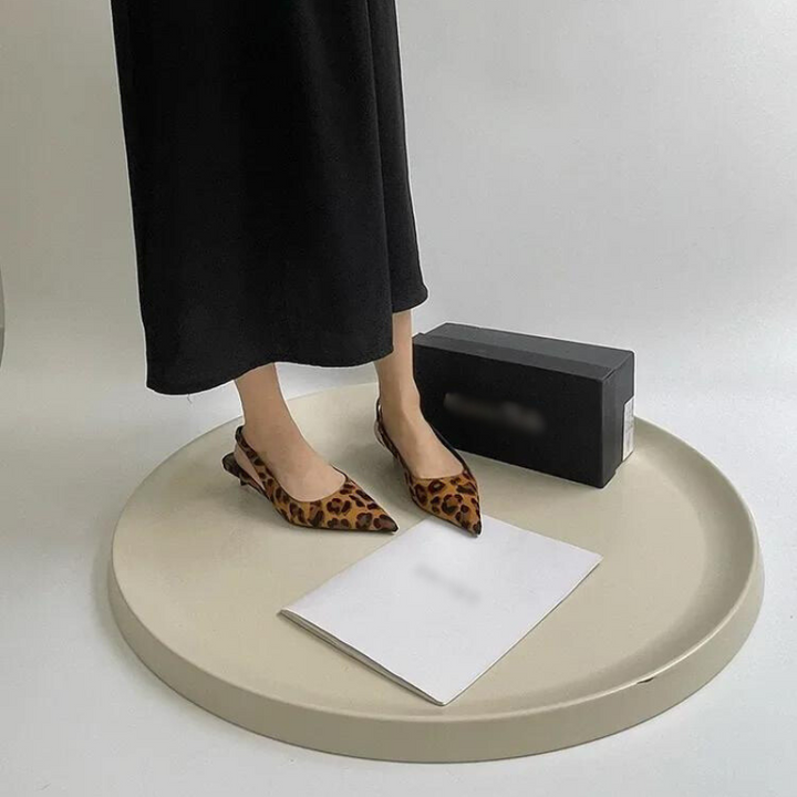 "Elegant dam leopard spetsiga klackar med slingback-rem, trendigt leopardmönster, chic design för sofistikerad stil."