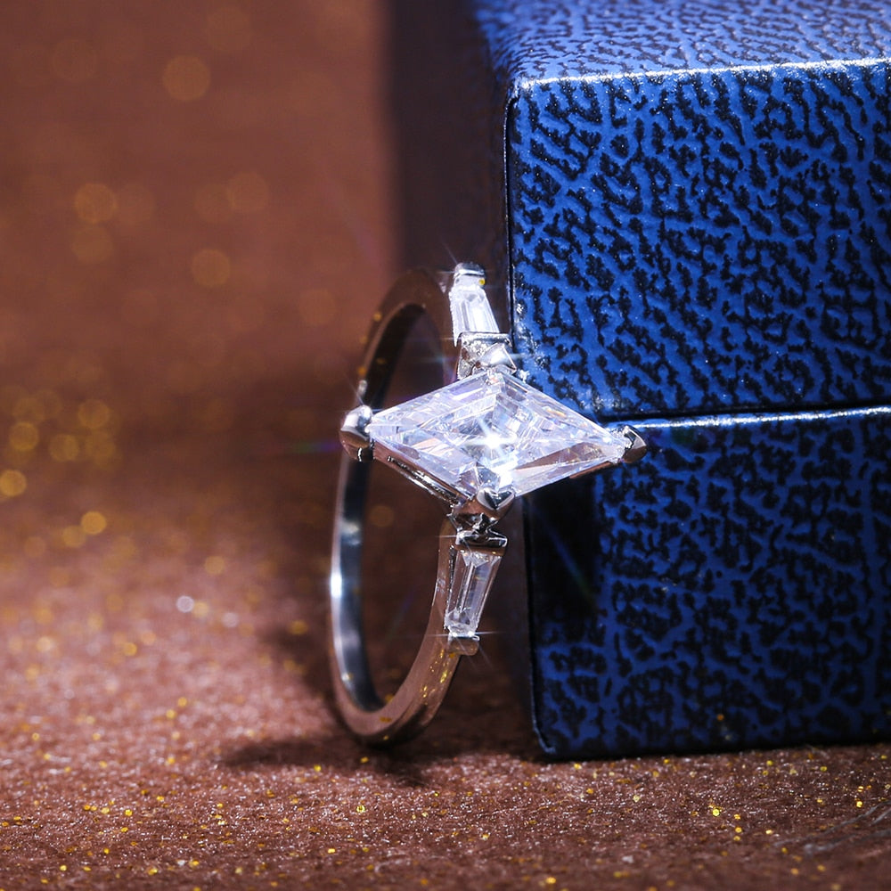 "Elegant dam solitärring med kantig urform, sterling silver, geometrisk moissanit, subtil och sofistikerad designaccessoar."