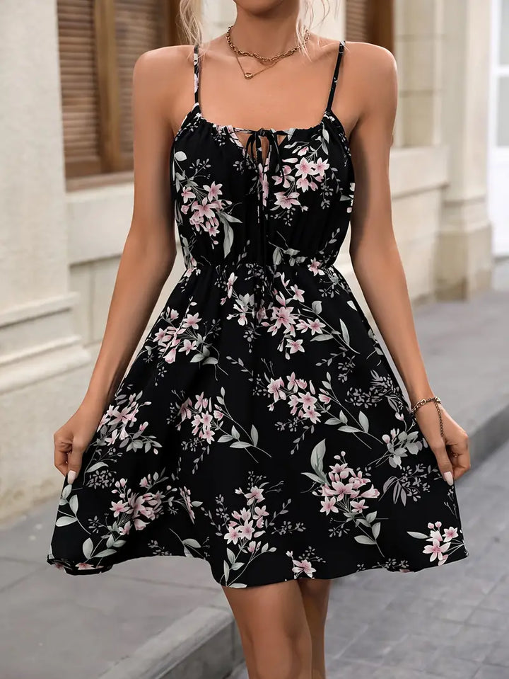 "Elegant dam sommarklänning med blommigt tryck, spaghettiband, knälång, lätt polyester för luftigt sommarbruk."