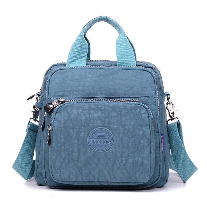 "Elegant dam vattenavvisande crossbodyväska i nylon med justerbar axelrem och flera fickor för stil och funktion."