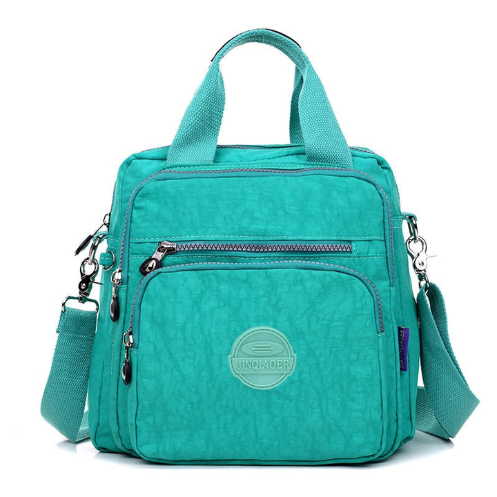 "Elegant dam vattenavvisande crossbodyväska i nylon med justerbar axelrem och flera fickor för stil och funktion."