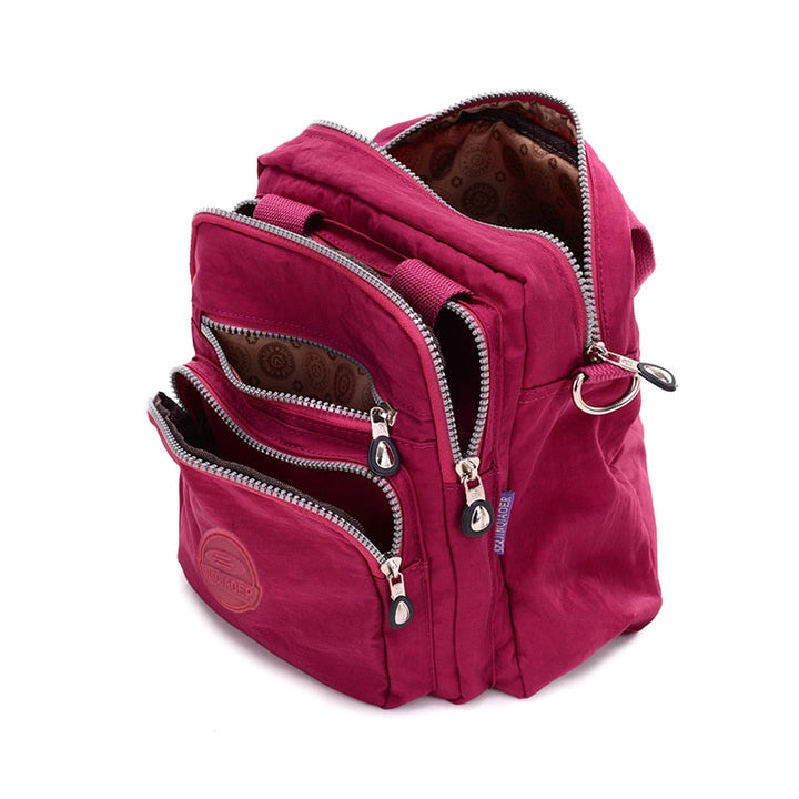 "Elegant dam vattenavvisande crossbodyväska i nylon med justerbar axelrem och flera fickor för stil och funktion."