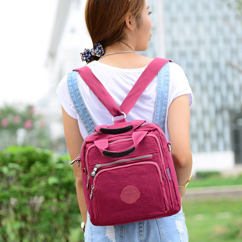 "Elegant dam vattenavvisande crossbodyväska i nylon med justerbar axelrem och flera fickor för stil och funktion."