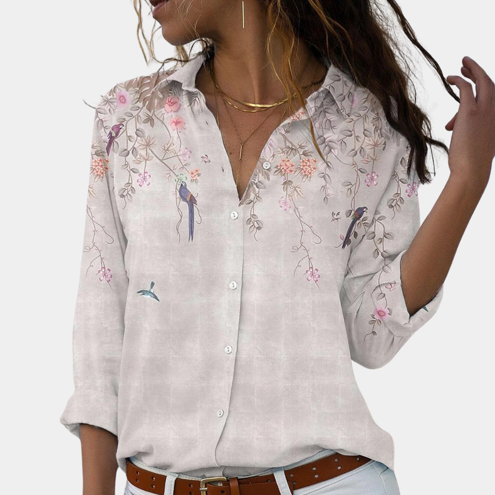 "Elegant damblus med blommiga broderier, puffärmar och luftigt tyg för romantisk och klassisk stil."