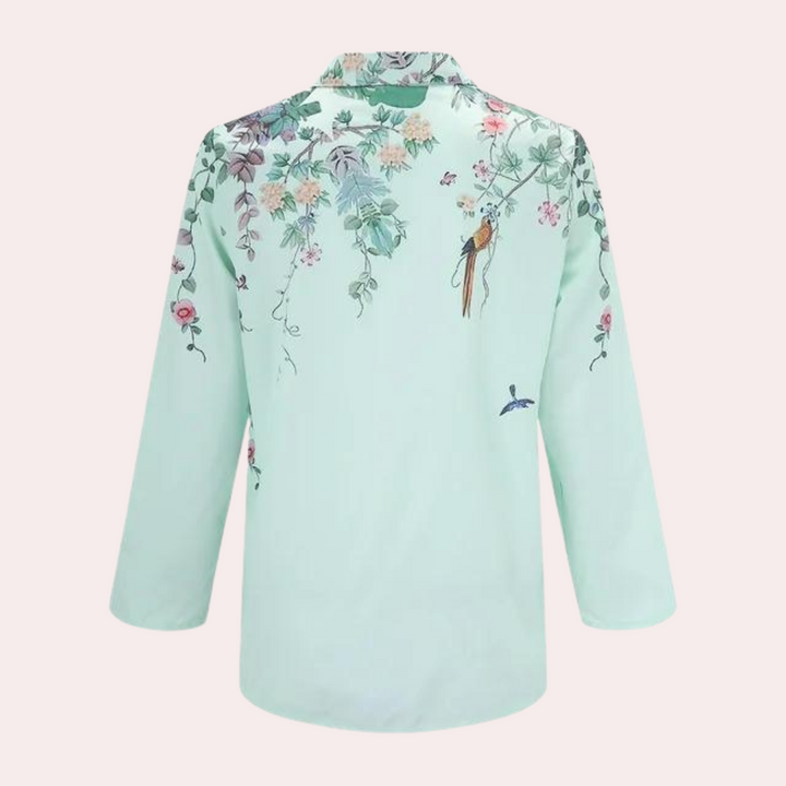 "Elegant damblus med blommiga broderier, puffärmar och luftigt tyg för romantisk och klassisk stil."