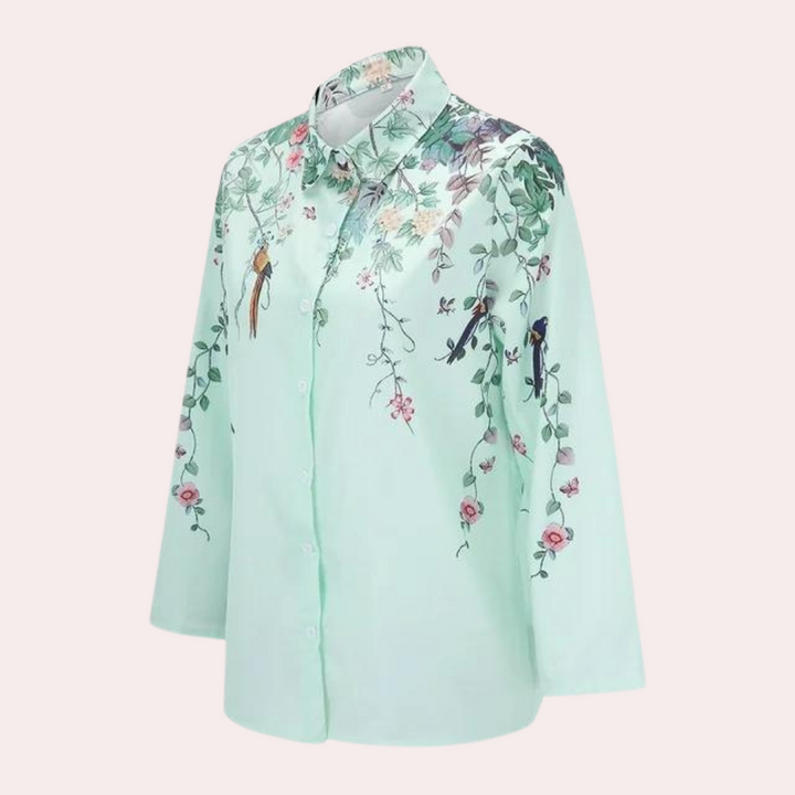 "Elegant damblus med blommiga broderier, puffärmar och luftigt tyg för romantisk och klassisk stil."