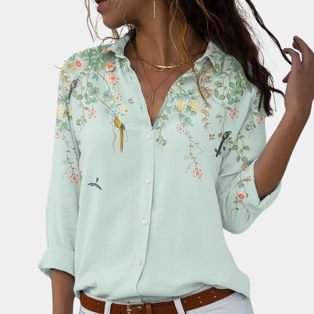 "Elegant damblus med blommiga broderier, puffärmar och luftigt tyg för romantisk och klassisk stil."