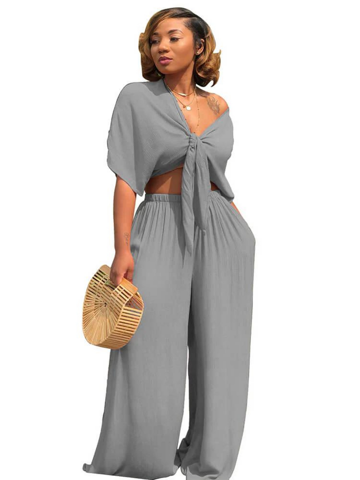 "Elegant damdressat set med crop top och vida raka byxor, skapar en stilren och självsäker look för moderna kvinnor."
