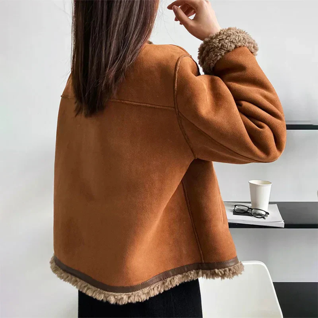 "Elegant damens shearling jacka med knäppning, varm och stilfull för vinterdagar, med sidofickor och detaljrik design."