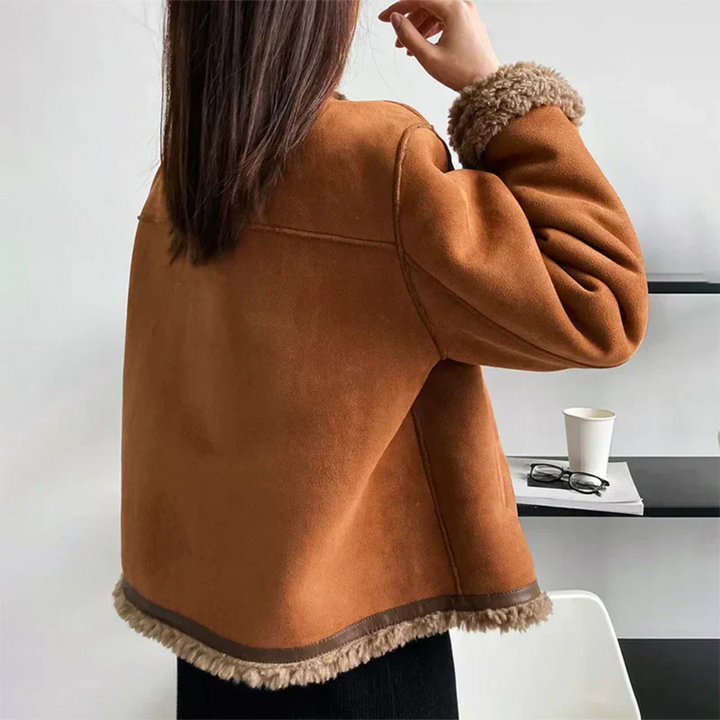 "Elegant damens shearling jacka med knäppning, varm och stilfull för vinterdagar, med sidofickor och detaljrik design."